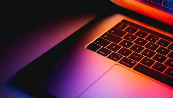 Laptop mit leuchtendem Bildschirm im Dunklen